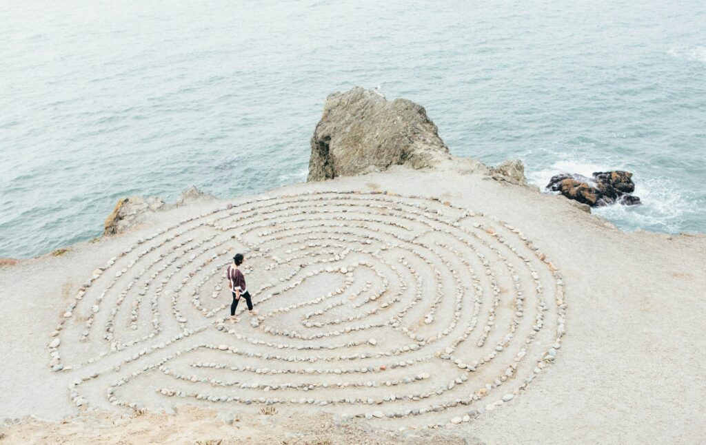 Laberinto circular en la arena simbolizando el proceso de coaching transpersonal: camino de introspección para conectar con el verdadero ser