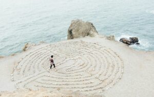 Laberinto circular en la arena simbolizando el proceso de coaching transpersonal: camino de introspección para conectar con el verdadero ser