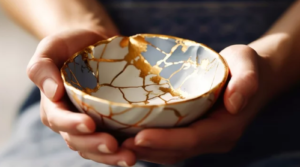 Tazón kintsugi roto y reparado con oro, símbolo del reprocesamiento de trauma: las heridas sanadas nos hacen más resilientes