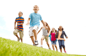 Grupo de niños corriendo y jugando al aire libre, imagen que ilustra los beneficios de las Barras de Access para el bienestar emocional infantil